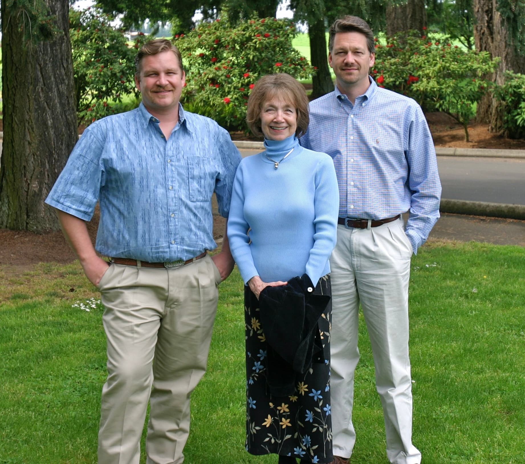 Wanda standing on a lawn between her two grown sons