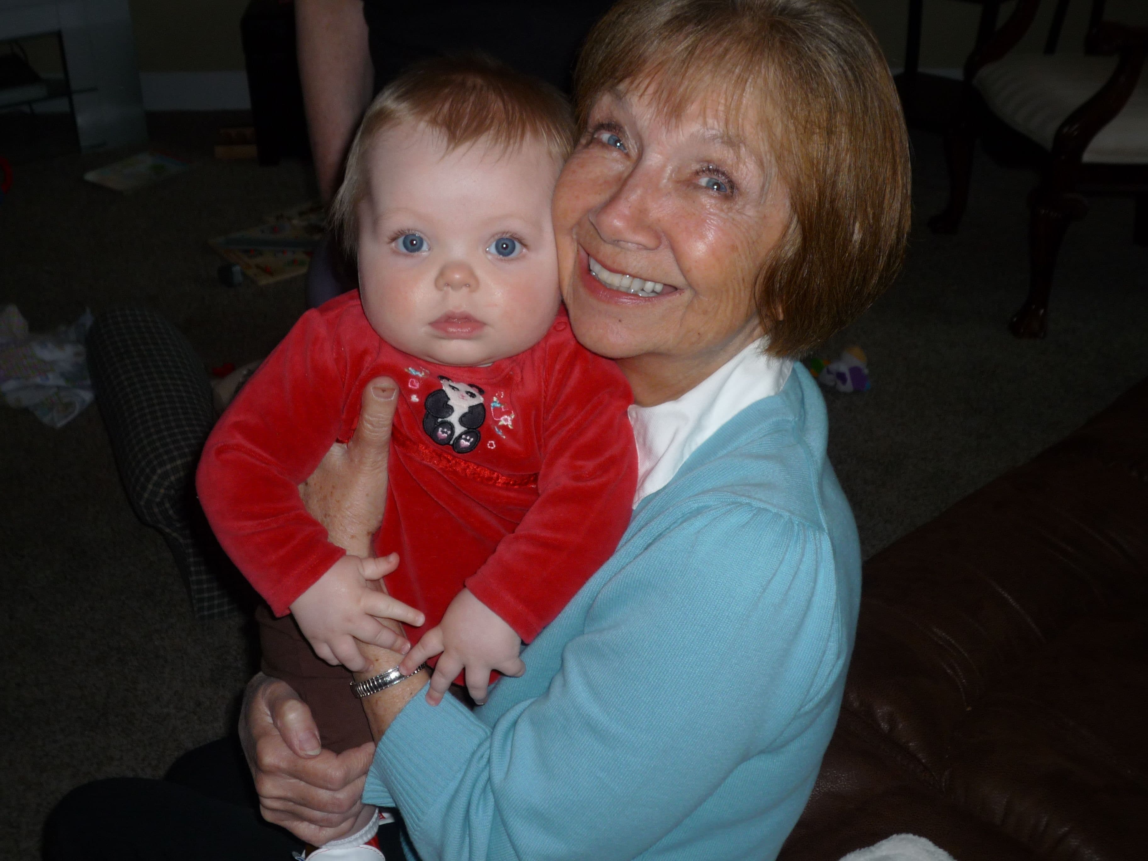 Wanda holding a baby in a red outfit, both looking towards the camera